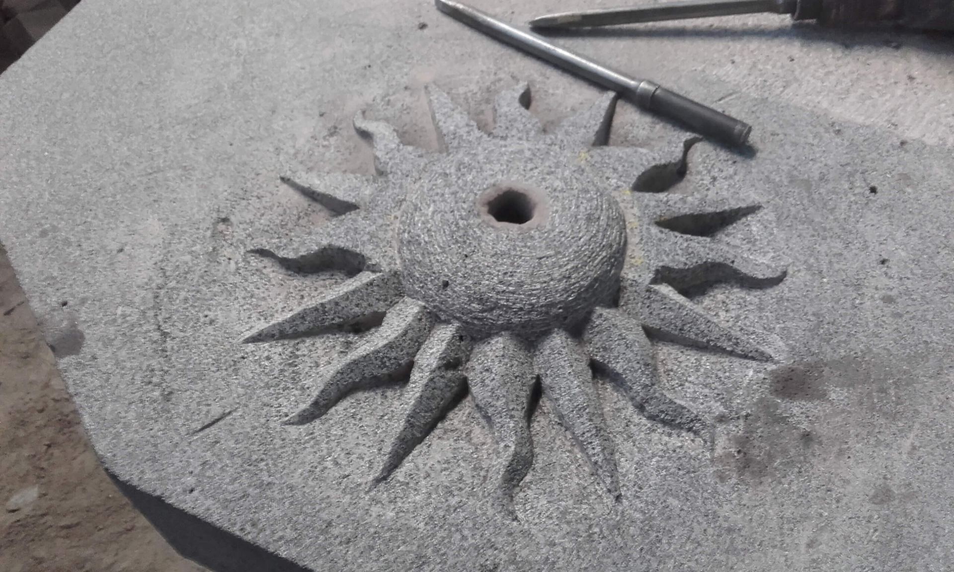 Soleil sculpté à la main dans le basalte de Bouzentès, dans l'atelier Pascal & Fils